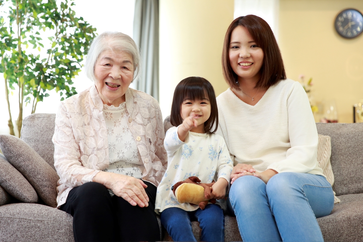 幼児と老人の介護を行う女性三人の写真