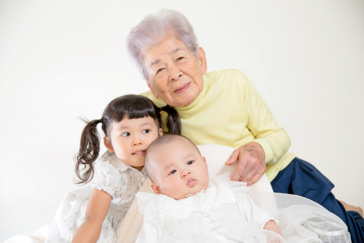 高齢女性と乳児、幼児の写真